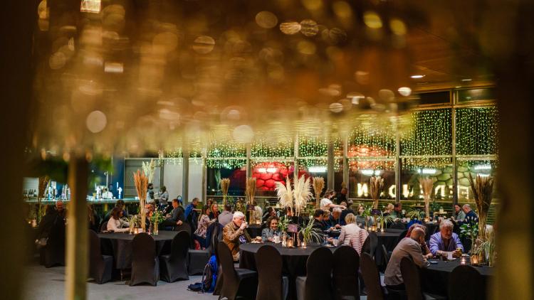 People sat around tables enjoying drinks and nibbles
