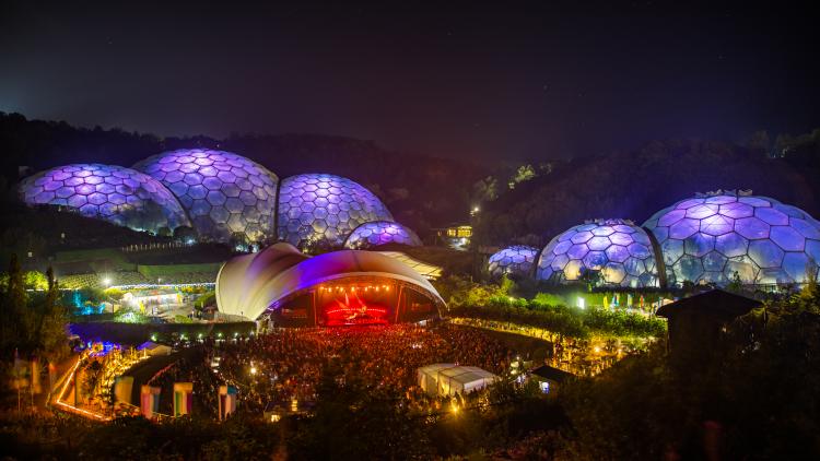 Wide view of an Eden Sessions concert, with purple lit up Biomes underneath starry sky