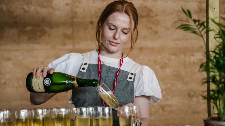 Woman pouring alcohol into glasses