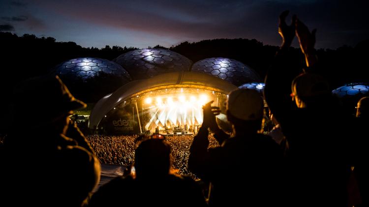 Wide shot Eden Sessions after sunset with lapping concert-goers on foreground
