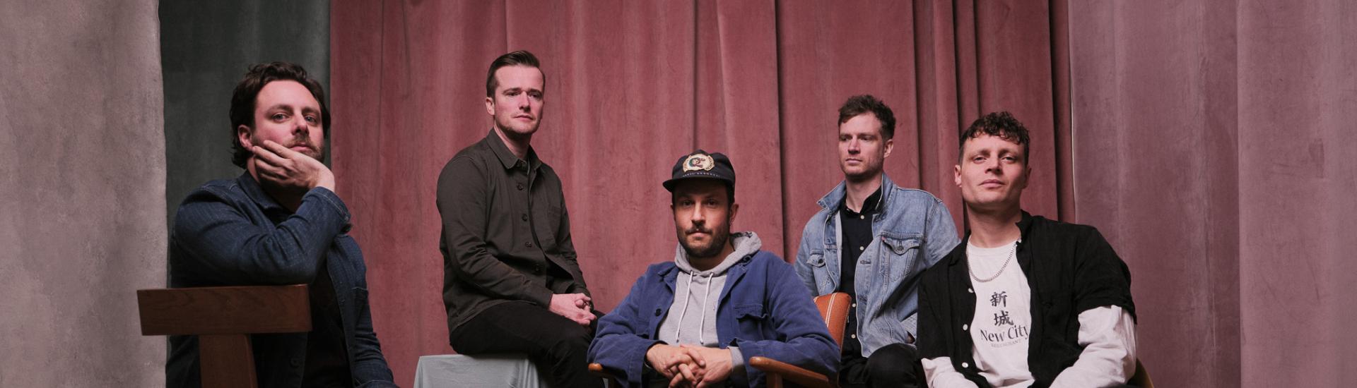 Maccabees band sat together as a group