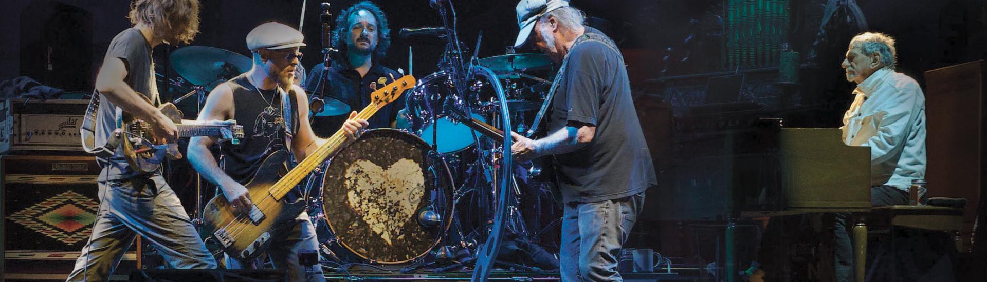 Neil Young playing on stage with his band