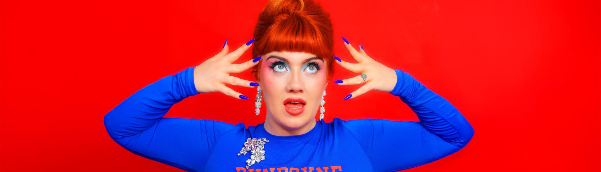 Singer CMAT Stood posing with hands to face